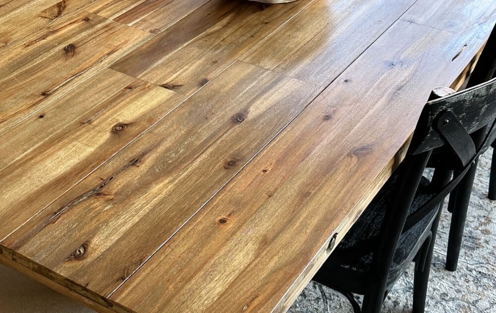 Applying a final oil finish to a wooden tabletop.